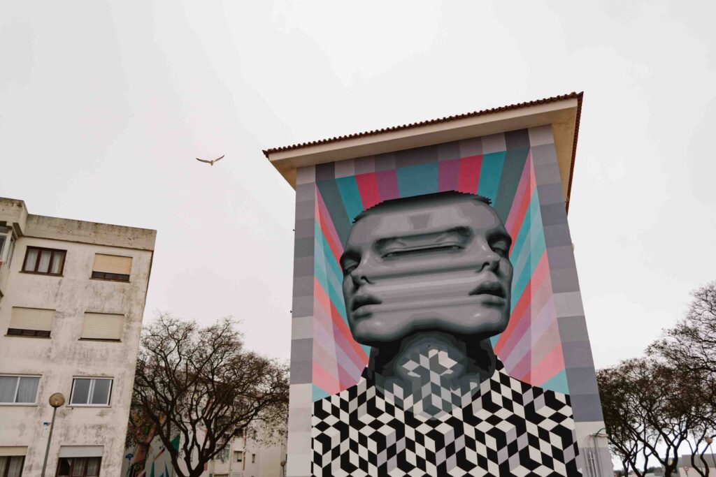 Incredible street art of a mirrored man on a colorful background in the Torre neighborhood of Cascais, Portugal on a cloudy day as part of Contiki's Make Travel Matter experience