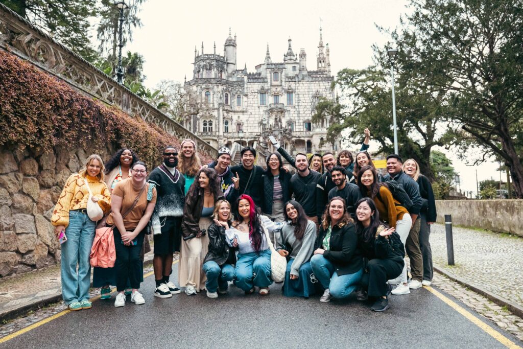 Group of 18 to 35 year old travelers posing for a group photo in front of Quinta de Regaliera in Sintra, Portugal