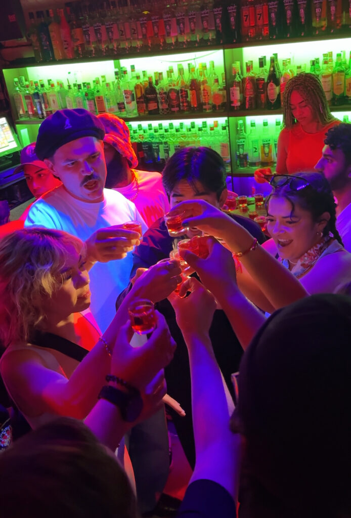 Group of travelers taking shots together in a bar in Madrid, Spain.