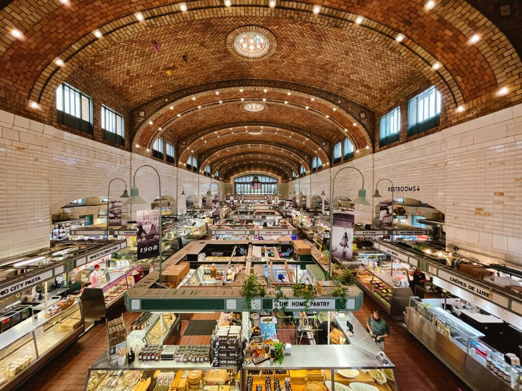 View of West Side Market in Cleveland from the second story upstairs where there is an open balcony and you can see all the restaurants and vendors, which makes for a great spot for lunch on your day trip to Cleveland itinerary
