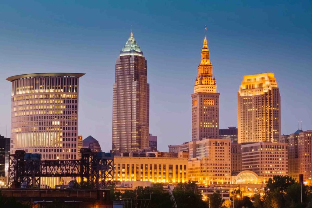Downtown Cleveland at night lit up with yellow lights as the sky turns dark during twilight