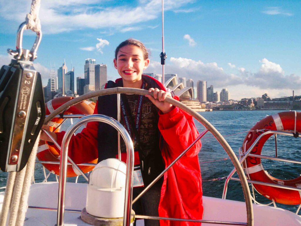 Sailing a boat in Sydney Harbor as a kid with Sydney Opera House in the background