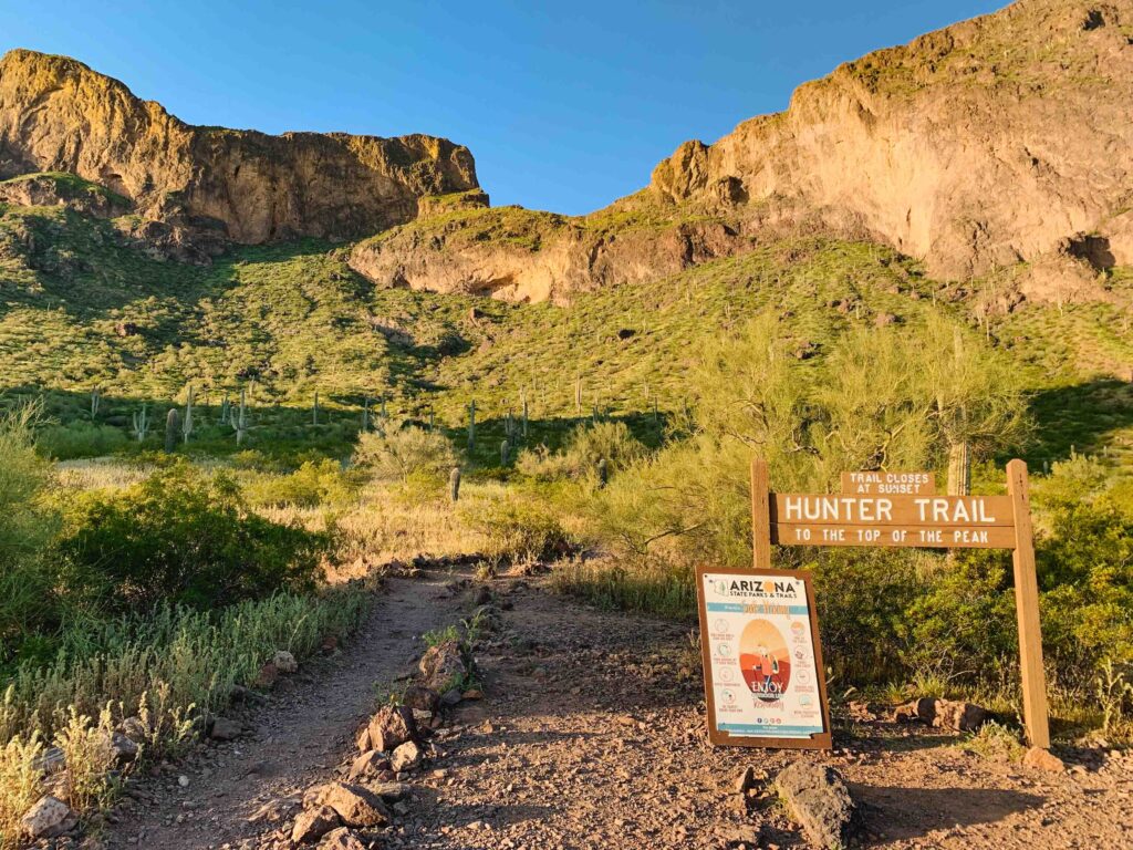Located in Pinal, Arizona is Picacho Peak State Park, where a hiking trail leading into the mountains during sunset is shown here.