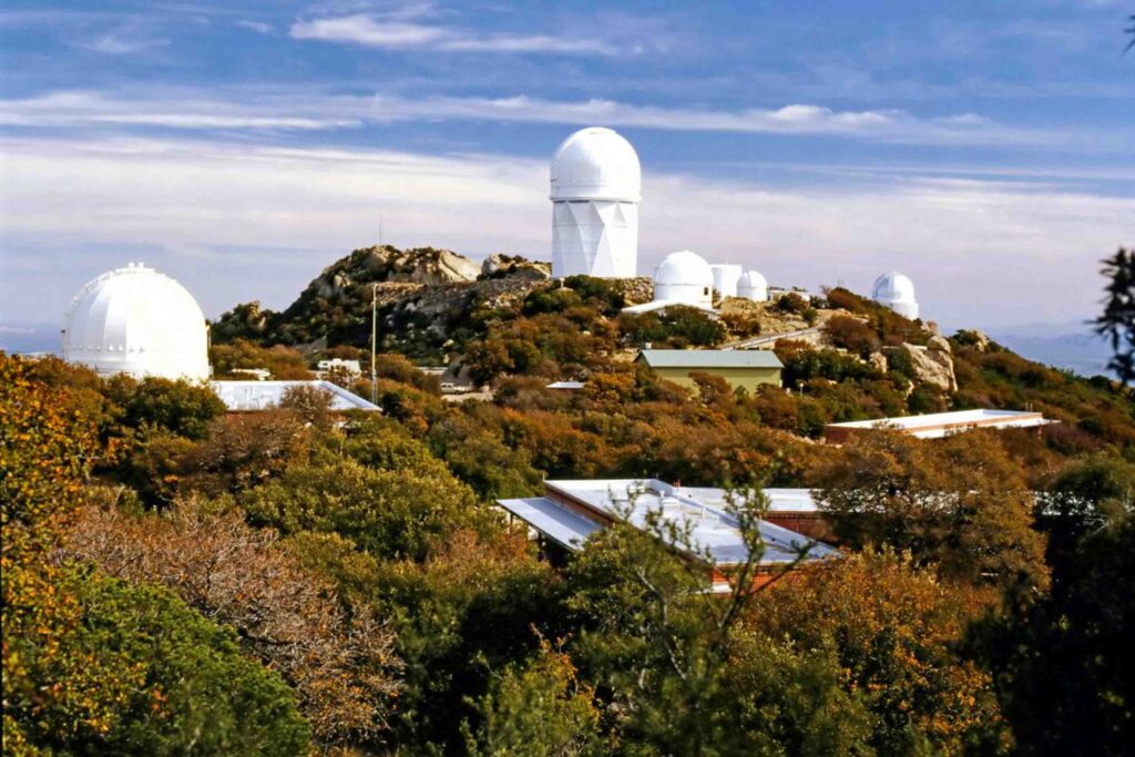 Desert hill with a number of telescopes on top as part of Kitt Peak National Observatory in Arizona