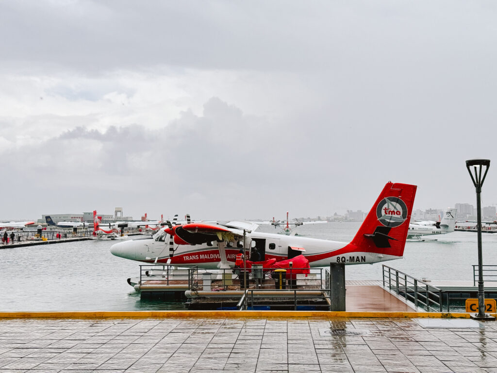 View of small seaplane that is red and white belonging to Trans Maldivian Airways